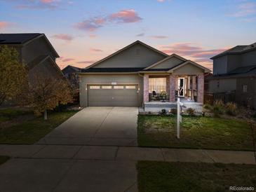Charming single-Gathering home featuring a brick porch, two-car garage, and well-maintained landscaping at 6267 N Dunkirk Ct, Aurora, CO 80019