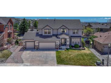 Charming two-story home with a three car garage and well-manicured lawn on a sunny day at 16184 Gold Creek Dr, Monument, CO 80132