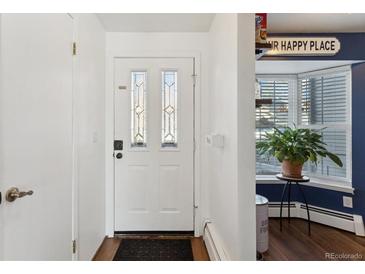 Inviting entryway with white door and wood flooring at 9044 W 63Rd Ave, Arvada, CO 80004