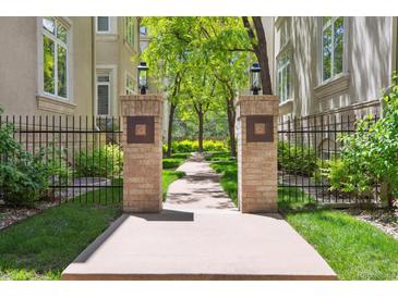 Beautiful walkway with brick pillars leads to lush landscaping and well-maintained buildings, enhancing the property's appeal at 335 Josephine St # D, Denver, CO 80206
