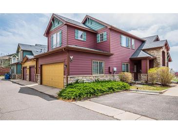 Two-story home with a two car garage, stone accents, and colorful facade at 2552 W 82Nd Ln # C, Westminster, CO 80031