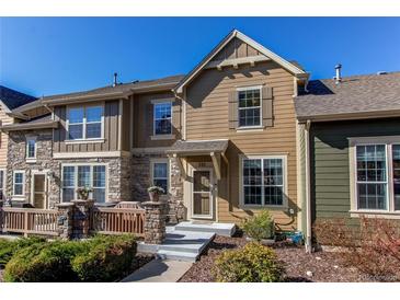 Charming two-story townhouse featuring a stone porch, wood siding, and manicured landscaping at 535 Lost Valley Pt, Castle Rock, CO 80108
