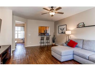 Inviting living room boasts wood floors, ceiling fan, and comfortable seating area with grey sectional at 535 Lost Valley Pt, Castle Rock, CO 80108