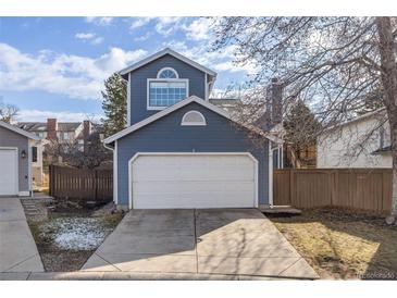 Charming home featuring a two-car garage, blue siding, and a neatly maintained front yard at 717 Walden Ct, Highlands Ranch, CO 80126