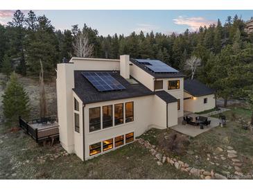 Stunning contemporary home with solar panels and inviting outdoor seating areas at 33379 Buffalo Park Rd, Evergreen, CO 80439