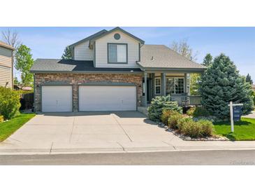 Charming two-story home featuring a stone facade, a two-car garage, and a welcoming front porch at 10570 Humboldt Peak Way, Parker, CO 80138