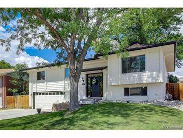 Charming two-story home with a well-maintained lawn and mature tree providing shade at 2221 S Arbutus Ct, Lakewood, CO 80228