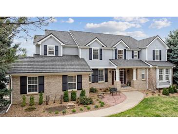 Stately two-story home featuring a brick and gray facade, complemented by mature landscaping and a welcoming walkway at 20363 E Top T Ranch Pl, Parker, CO 80134