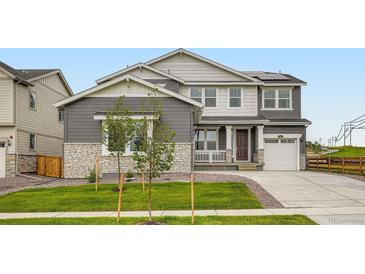 Charming two-story home boasts a manicured lawn, stone accents, and a welcoming front porch at 661 Sunrise St, Erie, CO 80516