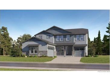 New construction home with two-car garage and stone accents on a well maintained lawn at 661 Sunrise St, Erie, CO 80516