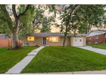 Charming brick home with mature trees, lush green lawn, and welcoming walkway leading to the front door at 2391 S Quitman St, Denver, CO 80219
