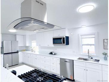 Bright kitchen with stainless steel appliances, white cabinetry, and granite countertops at 815 Plum Ave, Lochbuie, CO 80603