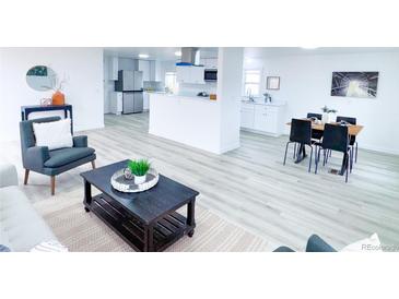 Bright and airy living room open to dining and kitchen with modern finishes and neutral tones at 815 Plum Ave, Lochbuie, CO 80603