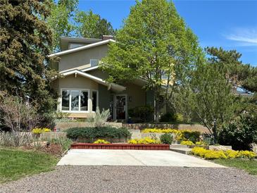 Charming two-story home with landscaped yard and colorful flowerbeds leading to the front entrance at 6843 Fairview Dr, Boulder, CO 80303