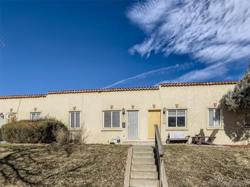 Charming townhomes with a Spanish tile roof line and steps leading to the units' front doors at 3081 W 18Th Ave, Denver, CO 80204