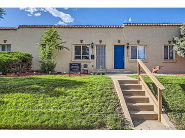 Charming home featuring a lush green lawn, landscaped garden, and inviting front entrance with a bright blue door at 3081 W 18Th Ave, Denver, CO 80204