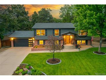 Charming two-story home with a manicured lawn, lush landscaping, and inviting front porch at 20520 E Regency Way, Parker, CO 80138