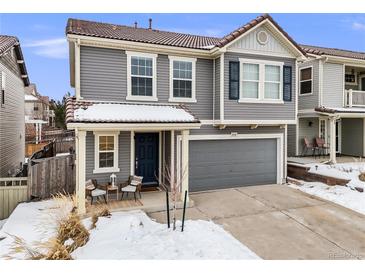 Charming gray two-story home featuring a cozy front porch, attached garage, and well-maintained landscaping at 2418 Coach House Loop, Castle Rock, CO 80109