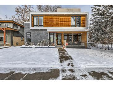 Modern two-story home with wood and gray siding, snowy front yard at 3915 W Byron Pl, Denver, CO 80212
