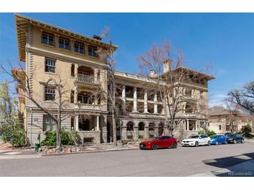 Elegant multi-story building showcasing classic architectural design with balconies and ample parking on a sunny day at 1301 N Ogden St # 1A, Denver, CO 80218