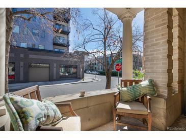 Inviting front porch with seating area perfect for enjoying the neighborhood views at 1301 N Ogden St # 1A, Denver, CO 80218