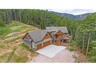 Stunning home with attached garage and outdoor deck surrounded by lush forest and mountain views at 14271 Timber Trl, Larkspur, CO 80118
