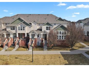 Inviting townhouse exterior featuring well-maintained lawns, brick accents, and charming entrances at 1443 S Emporia Ct, Aurora, CO 80247