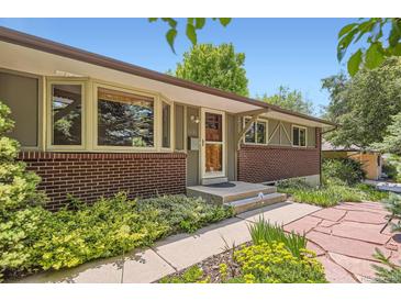 Charming single-story home featuring a brick facade, updated windows, and a beautifully landscaped walkway at 8292 E Lehigh Dr, Denver, CO 80237