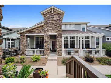 Charming home with a stone facade, covered porch, and manicured landscaping, providing excellent curb appeal at 5723 S Union Ct, Littleton, CO 80127
