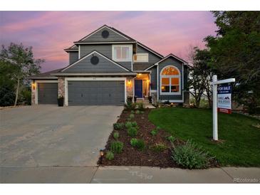 Charming two-story home featuring an attached two-car garage, manicured lawn, and professional landscaping at 810 Trail Ridge Dr, Louisville, CO 80027