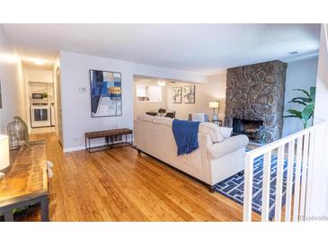 Inviting living room featuring a stone fireplace and natural light at 6420 E Bates Ave, Denver, CO 80222