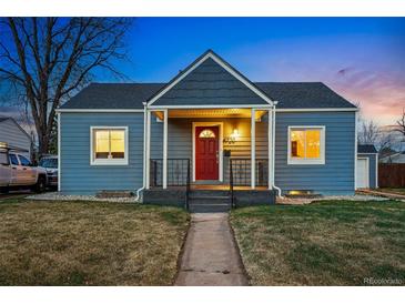 Charming home featuring a red front door, covered porch, and well-maintained lawn at dusk at 4720 Perry St, Denver, CO 80212