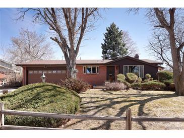 Charming one-story home featuring a well-manicured lawn, a brick facade, and an attached garage at 1288 S Drexel Way, Lakewood, CO 80232