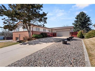 Beautiful shot of the home displaying the front lawn, driveway, and garage at 2799 S Ingalls Way, Denver, CO 80227