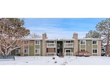 Charming condo complex with stone accents and balconies, surrounded by mature trees and snow-covered landscape at 4400 S Quebec St # 108L, Denver, CO 80237