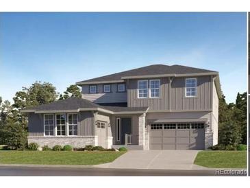 Charming two-story home with a two-car garage, a stone foundation, gray siding, and manicured landscaping at 630 Sunrise St, Erie, CO 80516