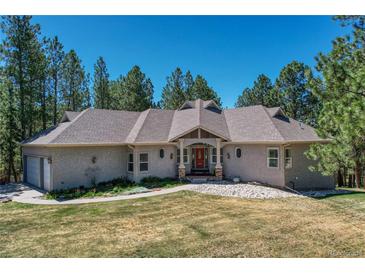 Charming home with a red front door, beautiful lawn and a well-maintained landscape at 4726 Pinon Dr, Elizabeth, CO 80107