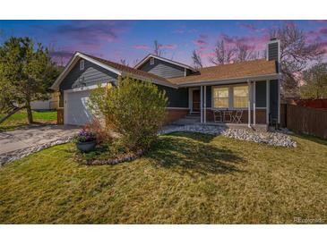 Charming home with a well-manicured lawn, rock garden, and inviting front porch at 482 Southpark Rd, Highlands Ranch, CO 80126