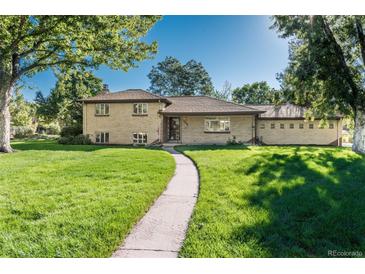 Well-maintained brick home featuring a lush, green lawn and mature shade trees at 5982 S Aberdeen St, Littleton, CO 80120