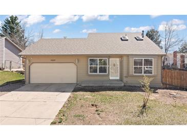 Ranch-style home featuring a one-car garage, neutral color palette, and a well-maintained lawn at 1603 S Flanders Way, Aurora, CO 80017