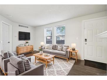 Bright living room with modern decor, wood floors, and large windows at 6705 S Field St # 803, Littleton, CO 80128