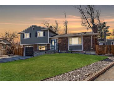 Charming two-story home with a well-manicured lawn, a brick facade, and an attached garage at 2863 S Biscay Ct, Aurora, CO 80013