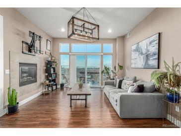 Bright living room with fireplace and access to a balcony boasting city views at 1488 Madison St # 505, Denver, CO 80206