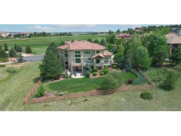 Expansive exterior of home features lush lawn, mature trees and landscaping, and views of surrounding community at 5603 Twilight Way, Parker, CO 80134