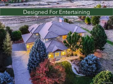 Stunning home with lush landscaping, mature trees, and a welcoming driveway for seamless indoor-outdoor entertaining at 5603 Twilight Way, Parker, CO 80134