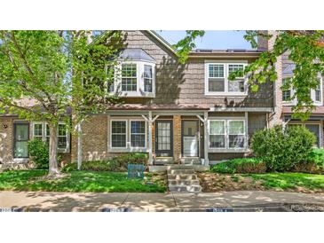 Charming townhouse featuring a brick facade, mature landscaping, and a welcoming entrance at 1209 S Flower Cir # C, Lakewood, CO 80232