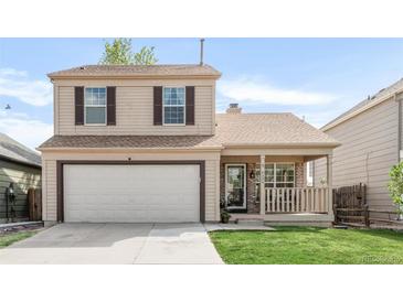 Charming two-story home featuring a well-maintained front yard and an attached two-car garage at 4534 Nepal St, Denver, CO 80249