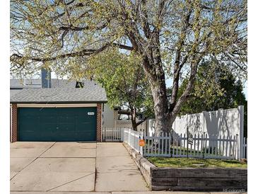 Charming home featuring a two-car garage and a well-maintained front yard, all beneath a large tree at 18902 E 17Th Ave, Aurora, CO 80011