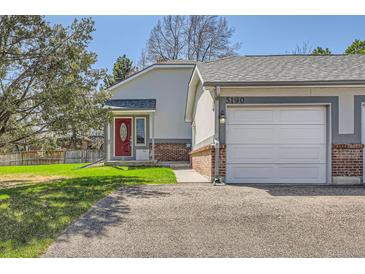 Charming home featuring a red front door, attached garage, and well-maintained lawn with an inviting appeal at 5190 S Emporia Way, Greenwood Village, CO 80111