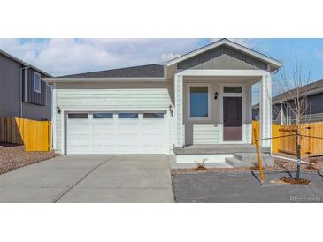 Charming single-Gathering home featuring an attached two-car garage and inviting front porch at 18318 E 93Rd Pl, Commerce City, CO 80022